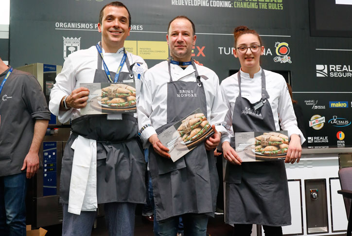 Frank Diaz on stage at Madrid Fusión 2019, holding his Signature Sandwich winner's certificate